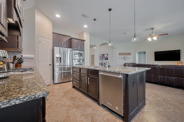 11918 Forest Moon Dr, Cypress, TX 77433 - kitchen with stainless steel appliances, a ceiling fan, dark brown cabinets, a sink, and an island with sink