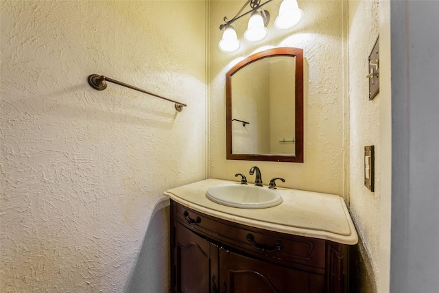 bathroom with vanity and a textured wall