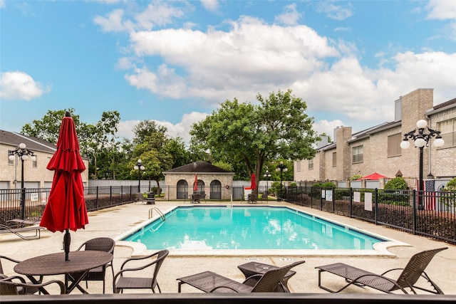 community pool featuring a patio and fence