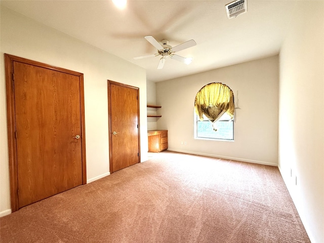 7110 W Mockingbird Ln, Pearland, TX 77584 - unfurnished bedroom featuring multiple closets, carpet, baseboards, and a ceiling fan