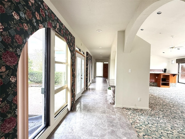 7110 W Mockingbird Ln, Pearland, TX 77584 - hall featuring baseboards, healthy amount of natural light, stone finish floors, arched walkways, and recessed lighting
