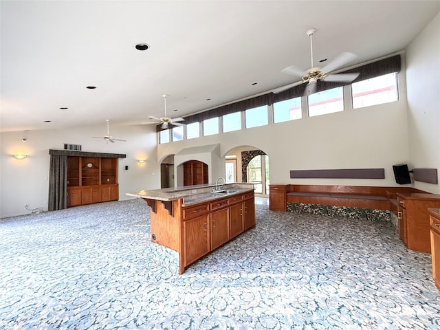 7110 W Mockingbird Ln, Pearland, TX 77584 - kitchen with ceiling fan, a sink, open floor plan, arched walkways, and a high ceiling