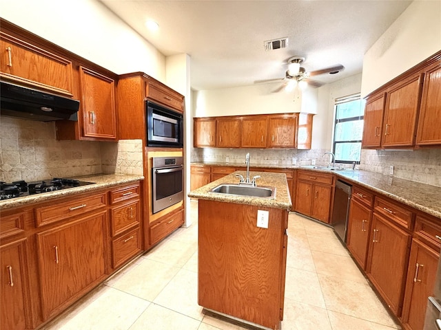 7110 W Mockingbird Ln, Pearland, TX 77584 - kitchen with appliances with stainless steel finishes, a sink, under cabinet range hood, and backsplash