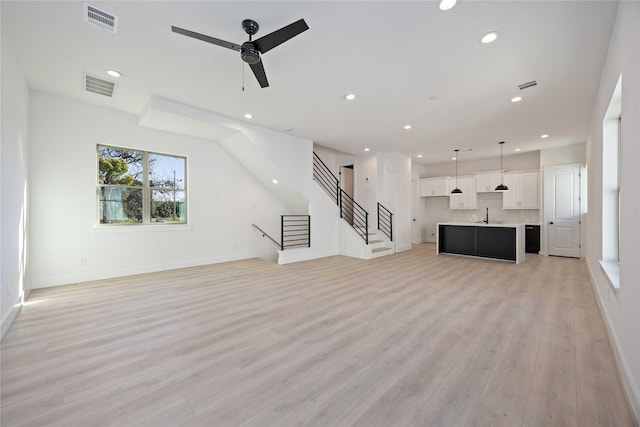 unfurnished living room with visible vents, recessed lighting, light wood-style flooring, and ceiling fan