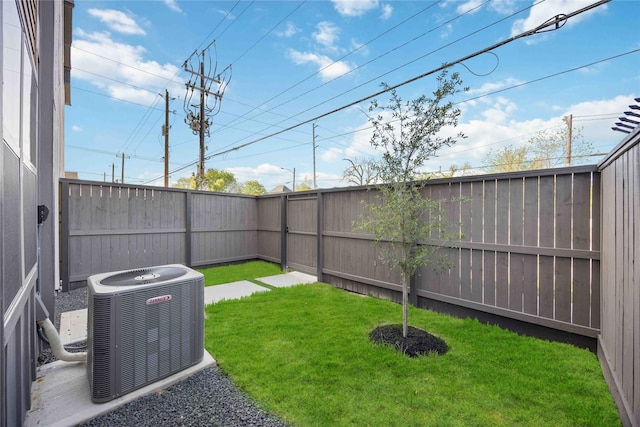 view of yard featuring a fenced backyard and central AC