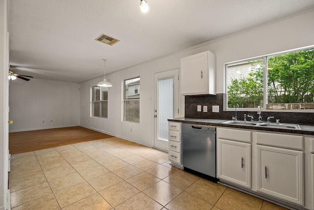 19627 Lighthouse Scene Ln, Cypress, TX 77433 - kitchen with stainless steel dishwasher, light tile patterned floors, dark countertops, and a sink
