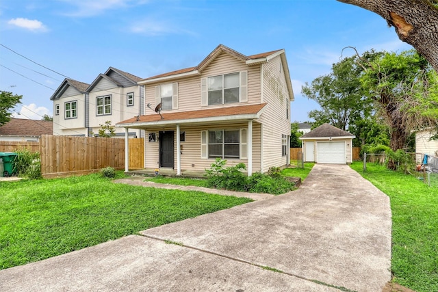 view of front of property featuring an outdoor structure, a front lawn, fence, and a detached garage
