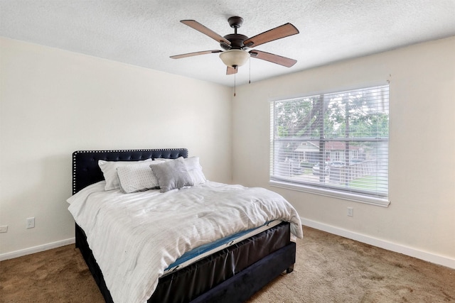 bedroom with light colored carpet, a ceiling fan, baseboards, and a textured ceiling