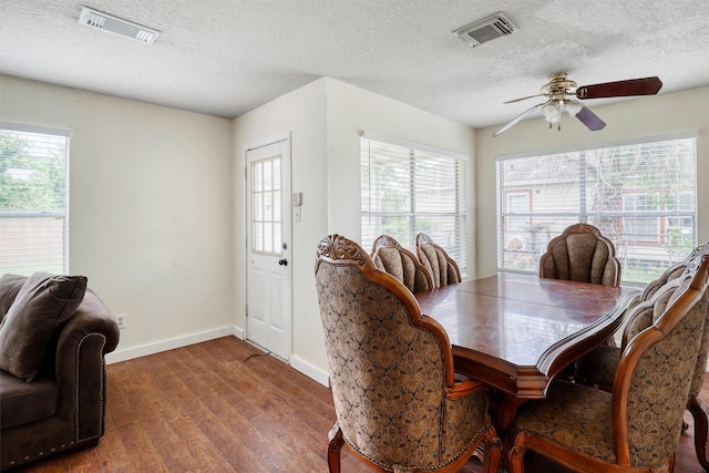 dining room with visible vents, a textured ceiling, ceiling fan, and wood finished floors