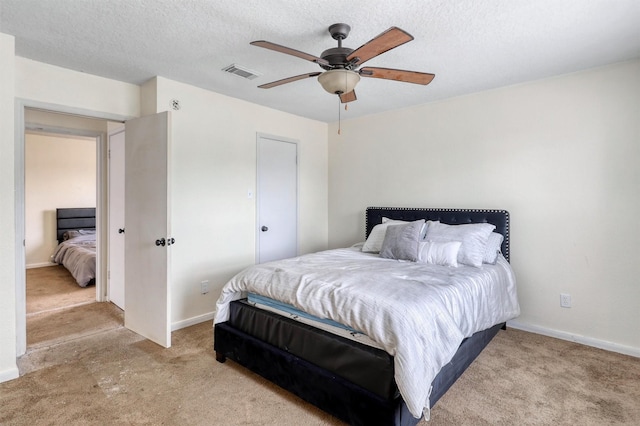 bedroom featuring baseboards, ceiling fan, light colored carpet, and visible vents