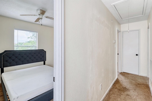 hall with baseboards, carpet, and attic access