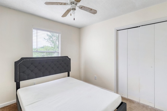 carpeted bedroom with ceiling fan and a closet
