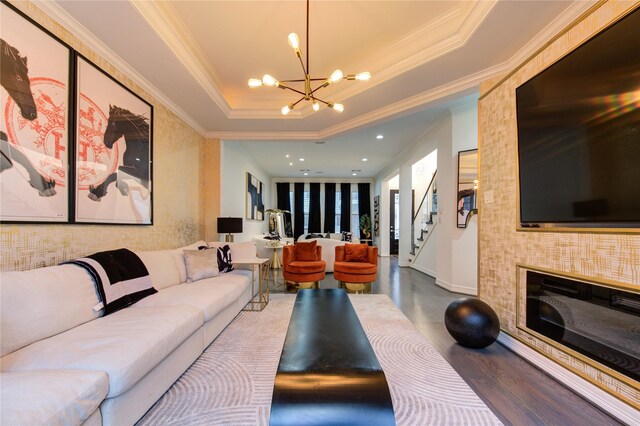living room featuring crown molding, stairway, recessed lighting, a raised ceiling, and a notable chandelier