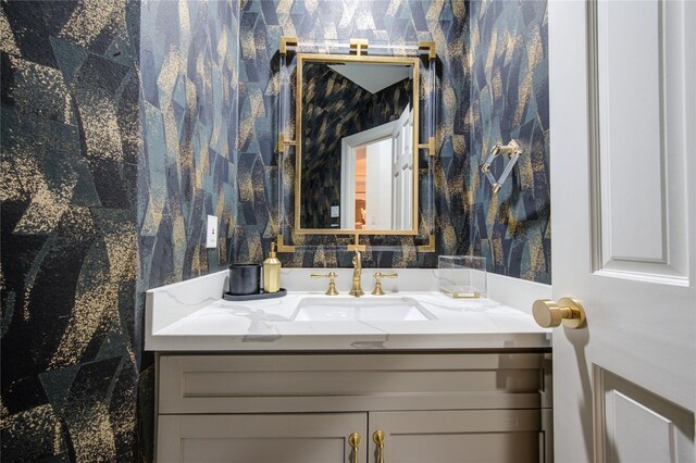 bathroom with wallpapered walls and vanity