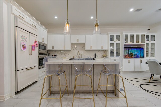kitchen featuring crown molding, white cabinets, built in appliances, light tile patterned floors, and backsplash