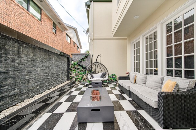 view of patio with an outdoor living space with a fire pit