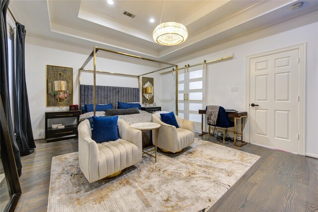 bedroom featuring an inviting chandelier, dark wood-type flooring, a tray ceiling, and visible vents