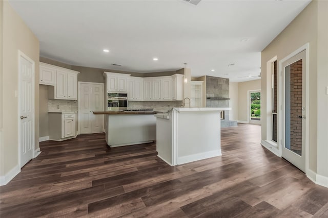 3515 Emerald Falls Ct, Houston, TX 77059 - kitchen with stainless steel oven, tasteful backsplash, a center island, dark wood-style flooring, and white cabinetry
