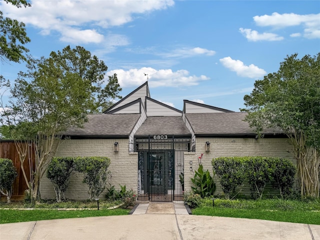 6803 Las Brisas Dr, Houston, TX 77083 - view of front of house with fence, a gate, a shingled roof, and brick siding