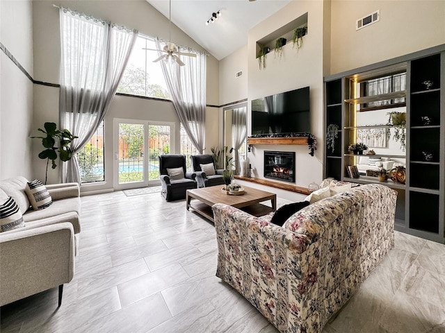 6803 Las Brisas Dr, Houston, TX 77083 - living room with high vaulted ceiling, visible vents, a glass covered fireplace, and marble finish floor