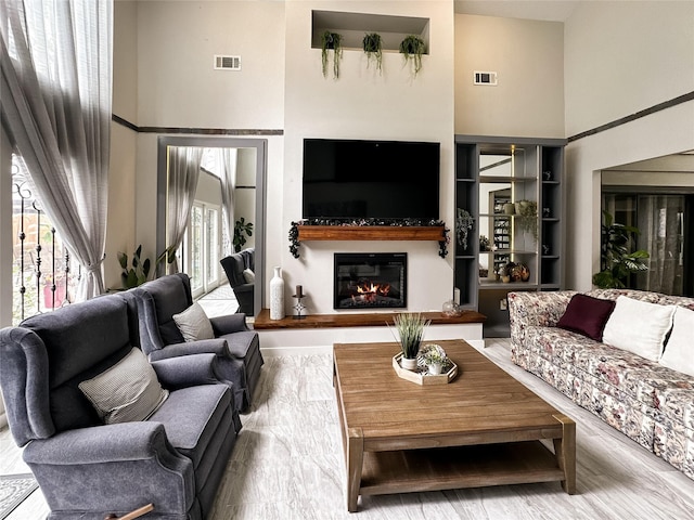 6803 Las Brisas Dr, Houston, TX 77083 - living area featuring a high ceiling, visible vents, and a glass covered fireplace