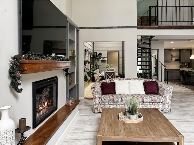 6803 Las Brisas Dr, Houston, TX 77083 - living room featuring stairs, a lit fireplace, wood finished floors, and a towering ceiling