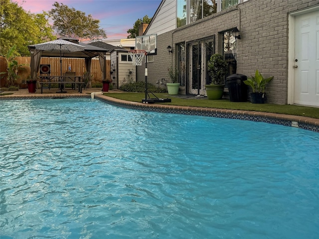 6803 Las Brisas Dr, Houston, TX 77083 - pool at dusk with fence, a gazebo, and a fenced in pool