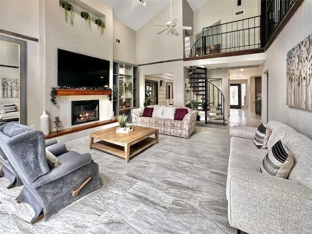 6803 Las Brisas Dr, Houston, TX 77083 - living room featuring high vaulted ceiling, a glass covered fireplace, marble finish floor, a ceiling fan, and stairway