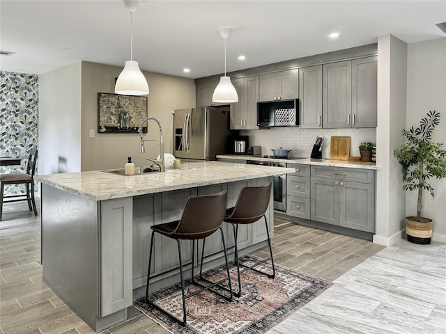 6803 Las Brisas Dr, Houston, TX 77083 - kitchen featuring wood tiled floor, a sink, appliances with stainless steel finishes, backsplash, and gray cabinetry
