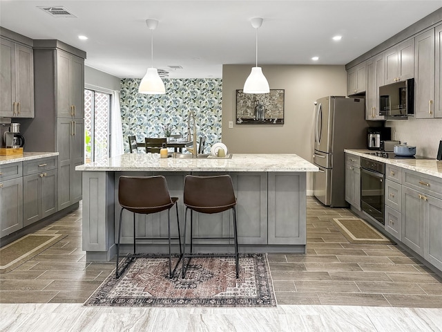 6803 Las Brisas Dr, Houston, TX 77083 - kitchen featuring a kitchen breakfast bar, black oven, gray cabinets, freestanding refrigerator, and light wood-type flooring