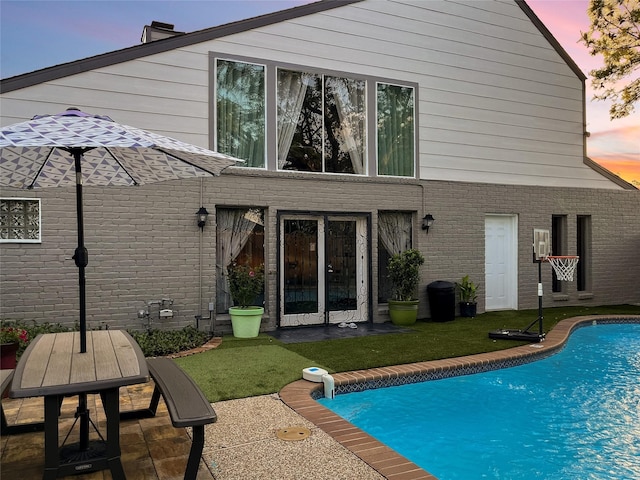 6803 Las Brisas Dr, Houston, TX 77083 - back of property with brick siding, an outdoor pool, a lawn, and a patio