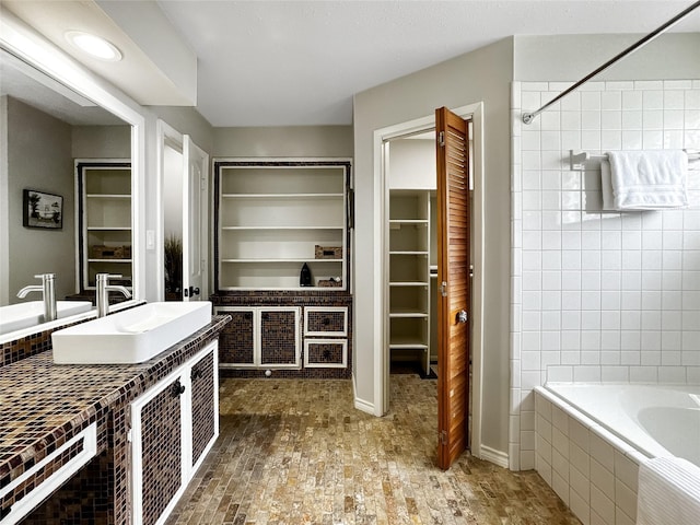 6803 Las Brisas Dr, Houston, TX 77083 - bathroom with a relaxing tiled tub, a tile shower, vanity, built in features, and a spacious closet
