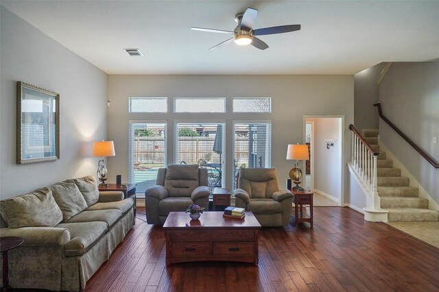 living room featuring ceiling fan, dark wood-type flooring, stairs, and visible vents