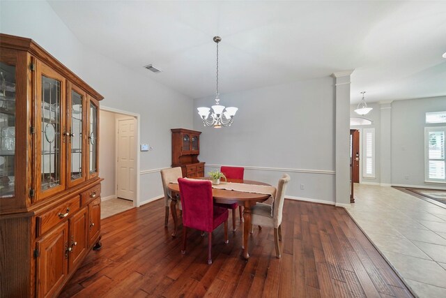 dining room featuring visible vents, baseboards, a chandelier, and hardwood / wood-style floors