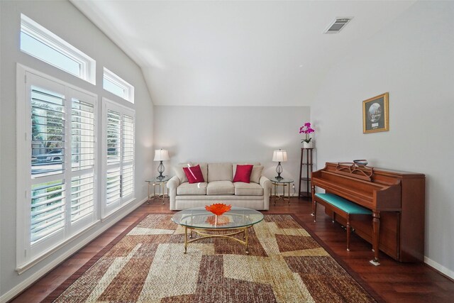 living area with baseboards, visible vents, wood finished floors, and lofted ceiling