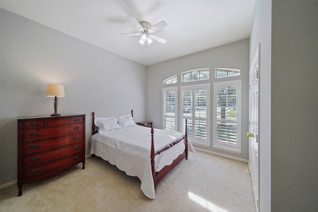 bedroom featuring ceiling fan, light carpet, and baseboards