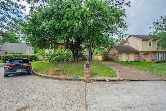 view of front of home featuring brick siding, fence, and a front yard