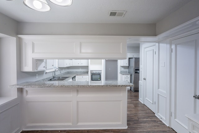 15807 Ripplewind Ln, Houston, TX 77068 - kitchen featuring a sink, appliances with stainless steel finishes, white cabinets, and a peninsula