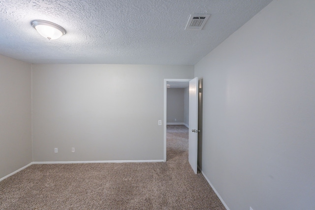 carpeted empty room with a textured ceiling, visible vents, and baseboards
