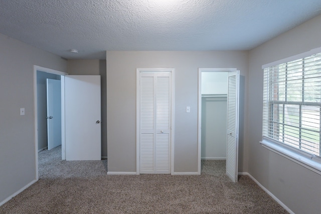 unfurnished bedroom with baseboards, a textured ceiling, and carpet