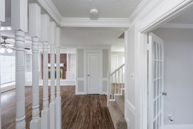 foyer entrance featuring crown molding, ceiling fan, a textured ceiling, stairs, and wood finished floors