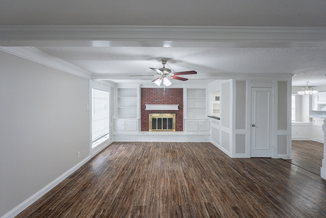 unfurnished living room with dark wood-style flooring, built in features, a brick fireplace, baseboards, and ceiling fan with notable chandelier