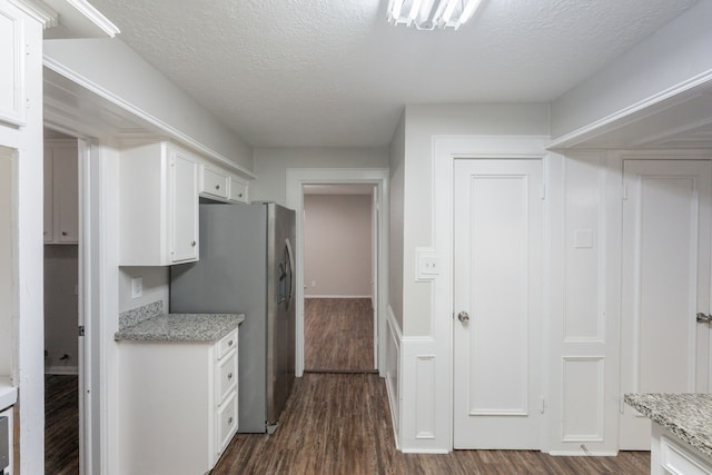 kitchen featuring stainless steel fridge with ice dispenser, a textured ceiling, dark wood finished floors, and white cabinetry