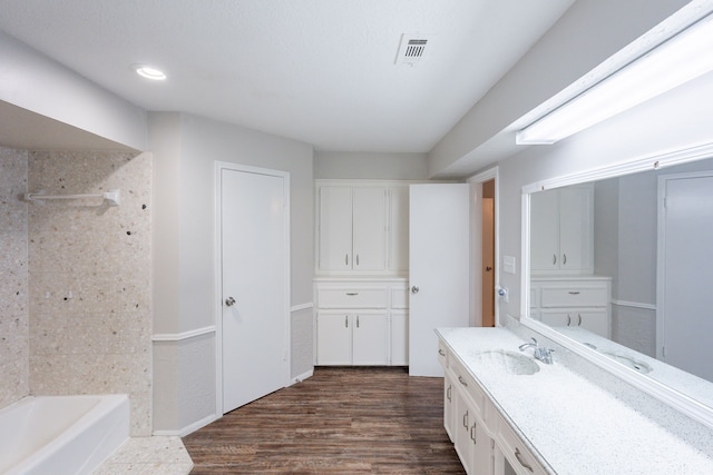 bathroom with vanity, recessed lighting, wood finished floors, shower / bathing tub combination, and visible vents