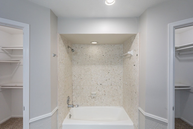 full bath with shower / bath combination, baseboards, and a spacious closet