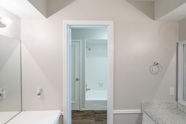 bathroom with shower / bathtub combination, baseboards, vanity, and wood finished floors