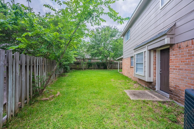 view of yard with cooling unit and a fenced backyard