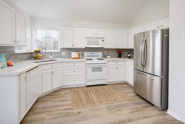 3107 Pleasant Forest Dr, College Station, TX 77845 - kitchen with a sink, light wood finished floors, white appliances, lofted ceiling, and backsplash