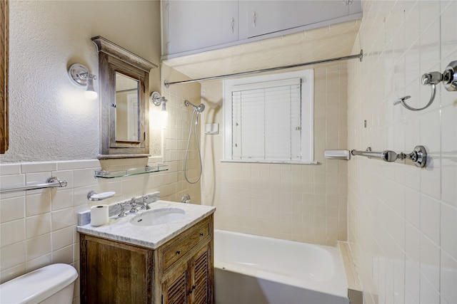 full bathroom with toilet, tile walls, tub / shower combination, and vanity
