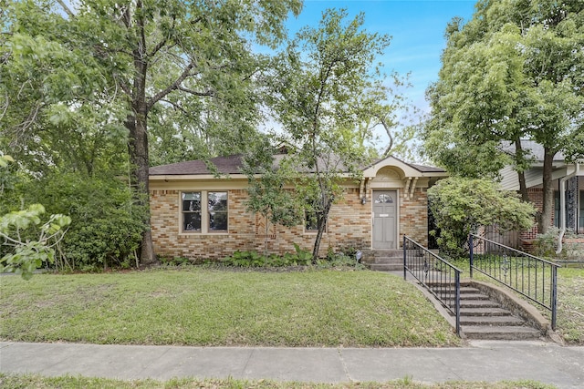 view of front of home with a front yard and brick siding